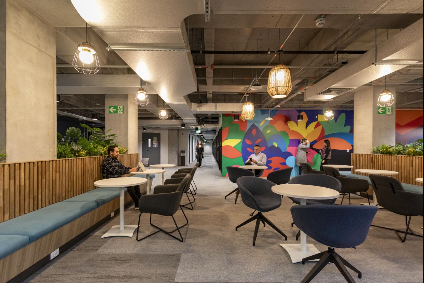 Emapta Offices - Vibrant office cafeteria with industrial finishes and colorful wall mural - Contract Workplaces.jpg